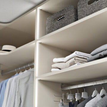 Notranjost vgradne omare s policami in integrirano osvetljitvijo.