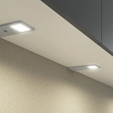 Interior of a built-in wardrobe with shelves and recessed lighting.